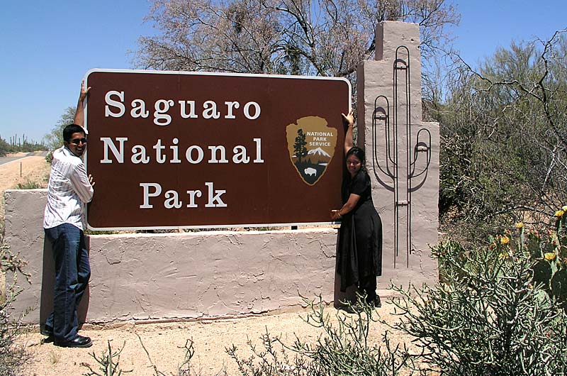 Jay Patel and Rinku Shah posing in front of the Saguaro National Park sign near Tucson, Arizona